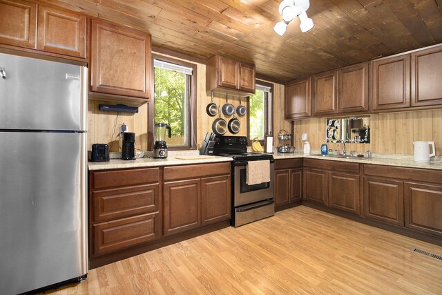 207 E Jefferson St, Cassopolis, MI 49031 - kitchen with stainless steel appliances, light wood-style floors, light countertops, wooden ceiling, and brown cabinetry