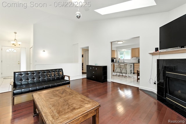 22288 Cass St, Farmington, MI 48335 - living room featuring a skylight, dark wood finished floors, a high end fireplace, and vaulted ceiling