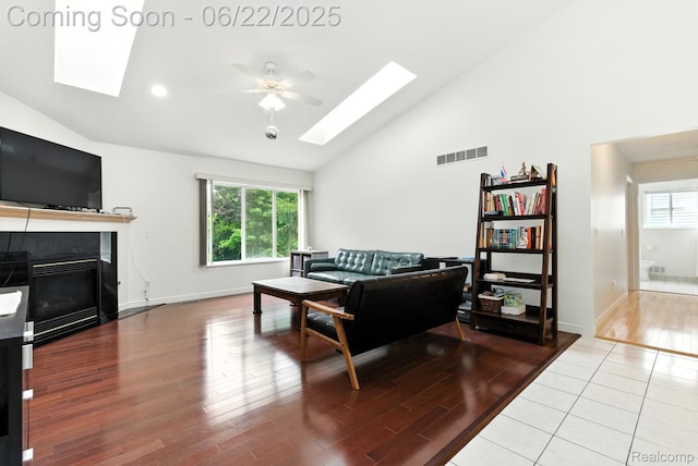 22288 Cass St, Farmington, MI 48335 - living area with a skylight, high vaulted ceiling, a ceiling fan, a fireplace, and wood finished floors