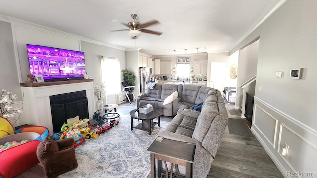 2315 Willow Ln, Grand Blanc, MI 48439 - living room with a fireplace, ceiling fan, ornamental molding, wood finished floors, and wainscoting