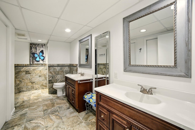 2350 155th Ave, Morley, MI 49336 - full bath with a drop ceiling, two vanities, tile walls, recessed lighting, and stone finish flooring