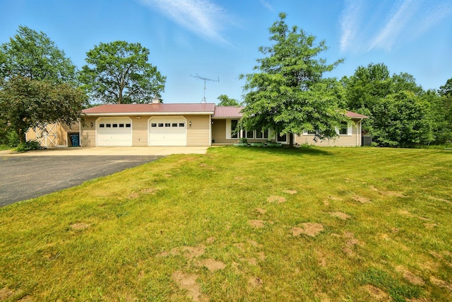 2350 155th Ave, Morley, MI 49336 - ranch-style house with a garage, driveway, a front yard, a chimney, and a metal roof