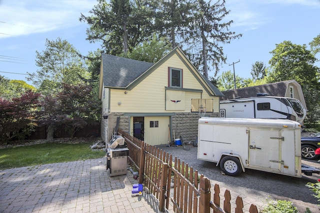 73640 Fulton St, Armada, MI 48005 - back of house with a shingled roof, stone siding, and a patio area