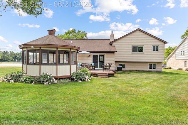 1306 Bishops Ter, Wixom, MI 48393 - back of property featuring a deck, a chimney, a yard, a shingled roof, and a sunroom