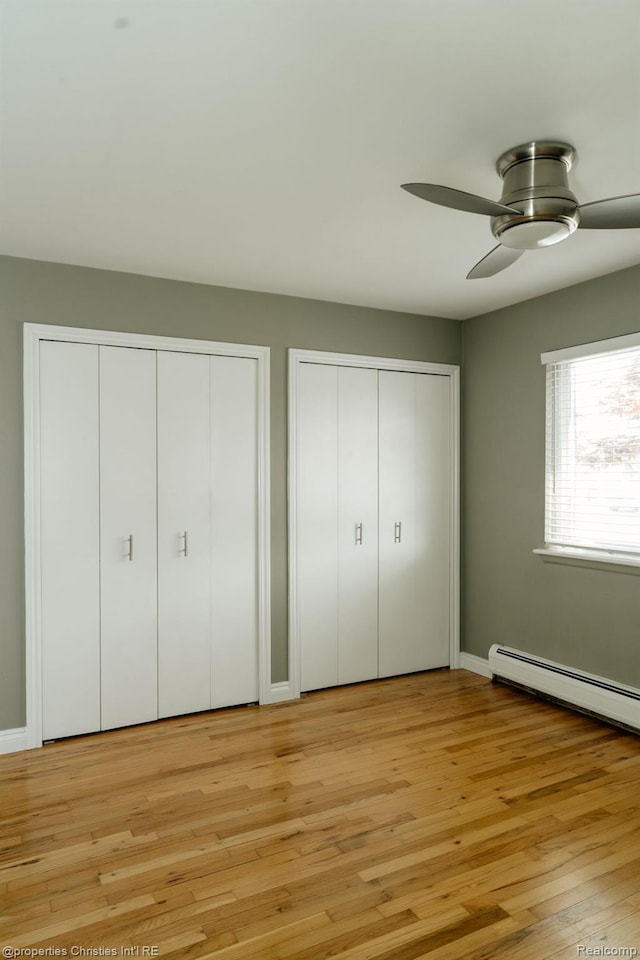 1715 E 14 Mile Rd, Birmingham, MI 48009 - unfurnished bedroom with multiple closets, light wood finished floors, a baseboard heating unit, and a ceiling fan