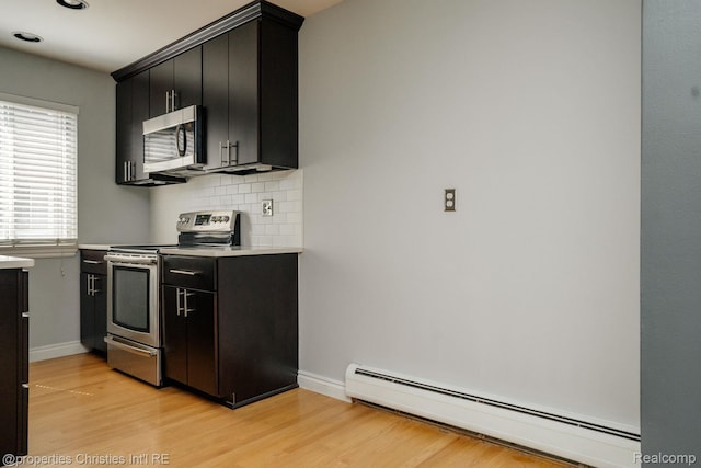 1715 E 14 Mile Rd, Birmingham, MI 48009 - kitchen with appliances with stainless steel finishes, a baseboard heating unit, dark cabinetry, light wood-type flooring, and light countertops