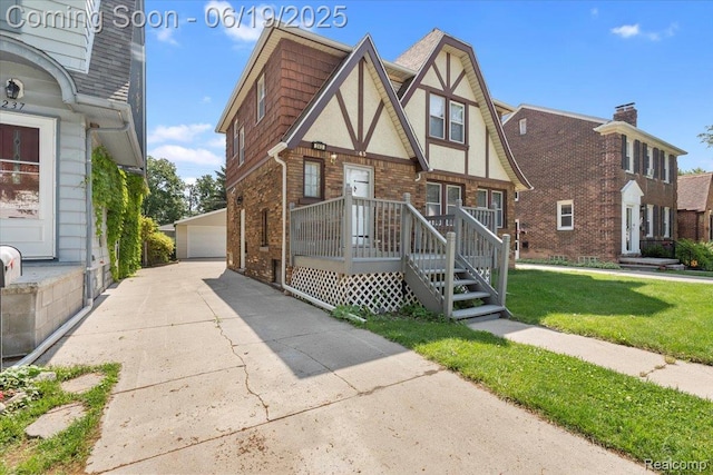 243 2nd St, Brownstown, MI 48192 - english style home with an outdoor structure, a garage, brick siding, a front lawn, and stucco siding