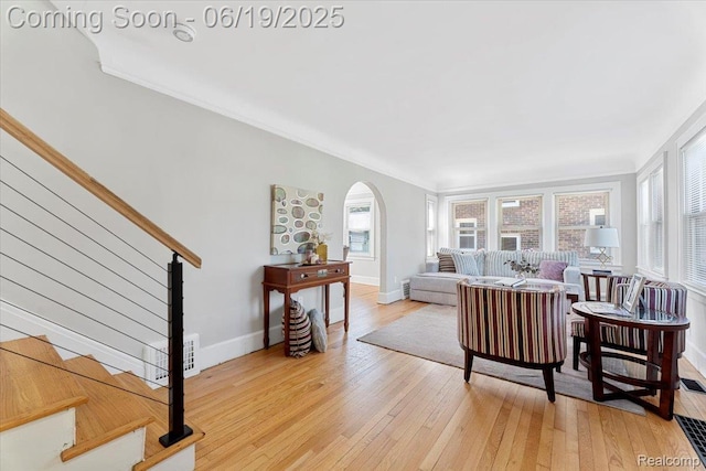 243 2nd St, Brownstown, MI 48192 - living room with arched walkways, light wood-style flooring, ornamental molding, and stairs