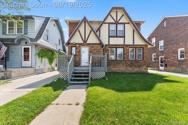 243 2nd St, Brownstown, MI 48192 - english style home featuring a front lawn, brick siding, and stucco siding