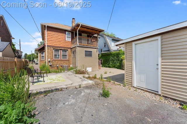 243 2nd St, Brownstown, MI 48192 - back of house with a balcony, a patio area, and a chimney