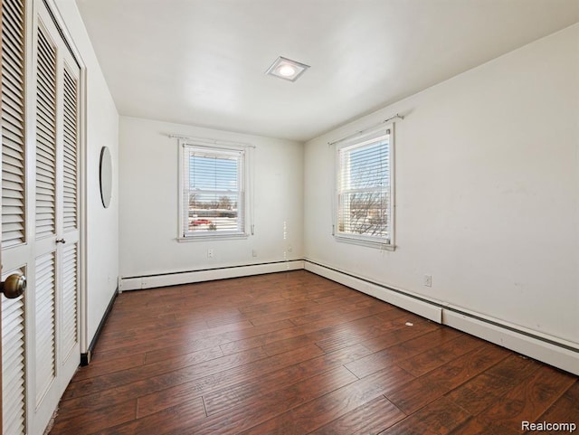 664 Buckingham Ave, Lincoln Park, MI 48146 - unfurnished bedroom with multiple windows, a closet, hardwood / wood-style floors, and a baseboard heating unit