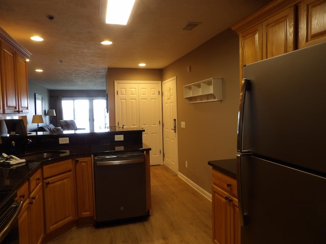 1246 Sunnyside Dr, Cadillac, MI 49601 - kitchen featuring freestanding refrigerator, stainless steel dishwasher, recessed lighting, a peninsula, and light wood finished floors