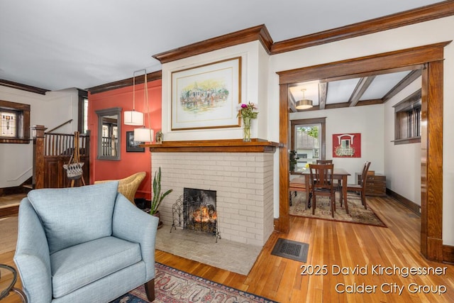 1328 Bemis St SE, Grand Rapids, MI 49506 - living area featuring crown molding, wood finished floors, stairway, and a brick fireplace