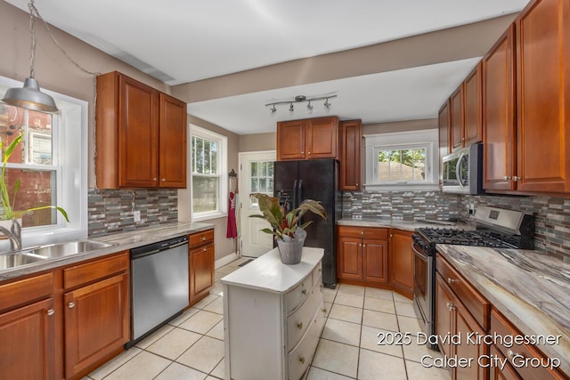 1328 Bemis St SE, Grand Rapids, MI 49506 - kitchen featuring appliances with stainless steel finishes, light countertops, decorative backsplash, and hanging light fixtures