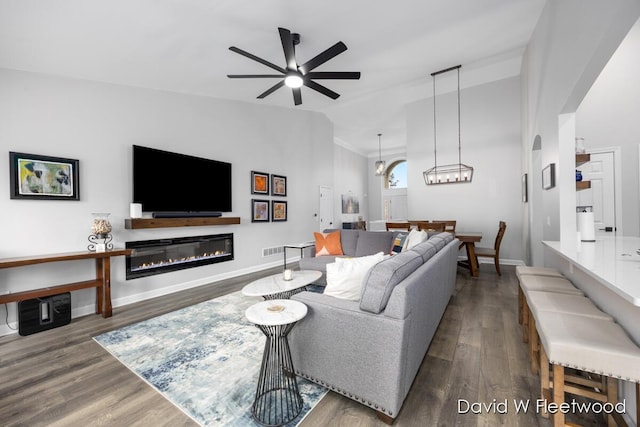 6935 Fairway Vista Dr SE, Caledonia, MI 49316 - living area featuring ceiling fan, wood finished floors, a glass covered fireplace, and vaulted ceiling