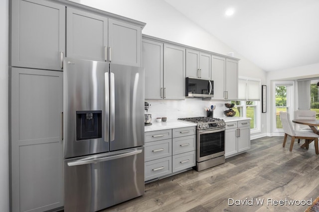 6935 Fairway Vista Dr SE, Caledonia, MI 49316 - kitchen with appliances with stainless steel finishes, gray cabinets, lofted ceiling, light countertops, and tasteful backsplash