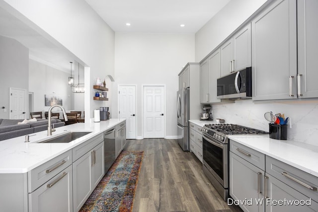 6935 Fairway Vista Dr SE, Caledonia, MI 49316 - kitchen featuring appliances with stainless steel finishes, gray cabinetry, a high ceiling, open floor plan, and dark wood-type flooring