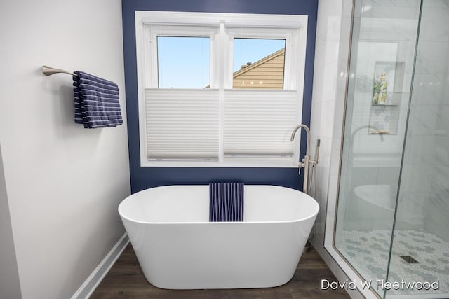 6935 Fairway Vista Dr SE, Caledonia, MI 49316 - full bathroom featuring a freestanding bath, a shower stall, and wood finished floors