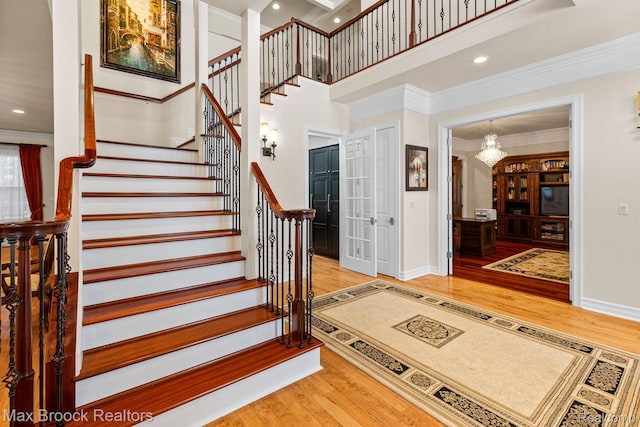 5626 Shadow Ln, Bloomfield Hills, MI 48302 - stairs featuring wood finished floors, crown molding, a chandelier, a towering ceiling, and recessed lighting