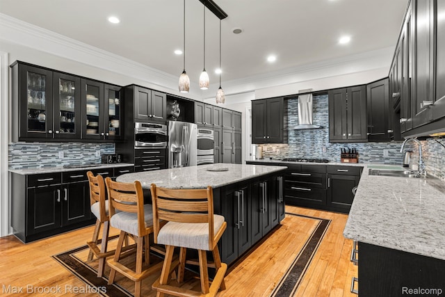 5626 Shadow Ln, Bloomfield Hills, MI 48302 - kitchen with dark cabinets, wall chimney range hood, estacked washer and dryer, a center island, and backsplash