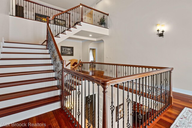 5626 Shadow Ln, Bloomfield Hills, MI 48302 - staircase featuring wood finished floors, a high ceiling, and arched walkways