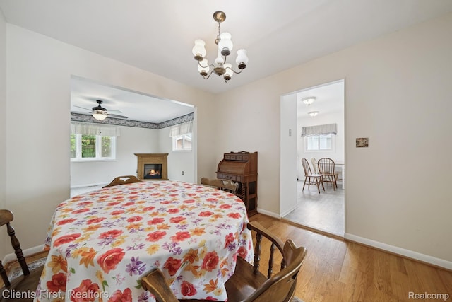 939 Deering St, Garden City, MI 48135 - dining room featuring light wood finished floors, a glass covered fireplace, a chandelier, and ceiling fan
