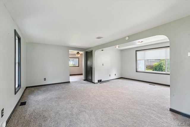 605 Oak St, Hudson, MI 49247 - empty room with arched walkways, carpet flooring, a ceiling fan, and a smoke detector