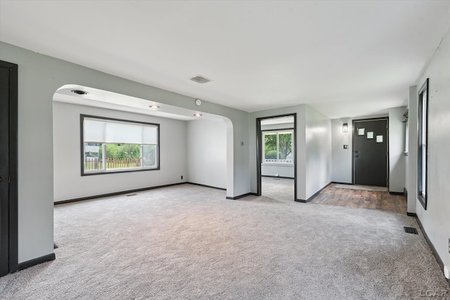 605 Oak St, Hudson, MI 49247 - unfurnished room with carpet floors, healthy amount of natural light, and arched walkways