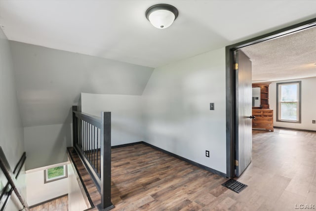 605 Oak St, Hudson, MI 49247 - staircase featuring wood finished floors and vaulted ceiling