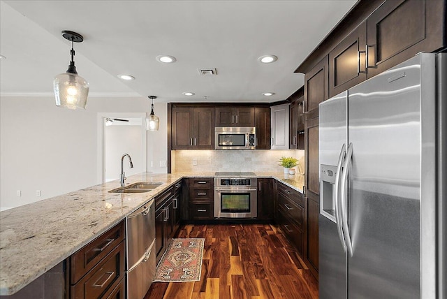 43 Campau Cir NW, Grand Rapids, MI 49503 - kitchen with stainless steel appliances, crown molding, dark brown cabinets, dark wood-style floors, and light stone counters