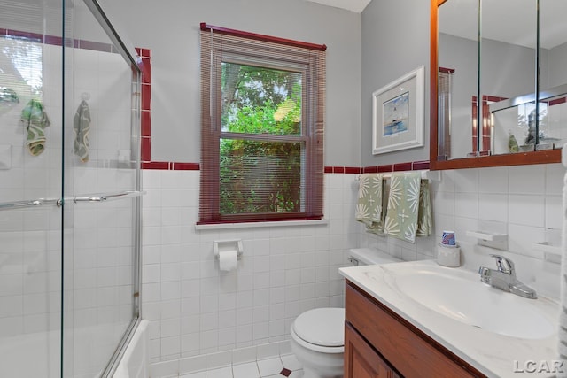 1043 Orchard Rd, Adrian, MI 49221 - bathroom featuring vanity, enclosed tub / shower combo, tile walls, and a wainscoted wall