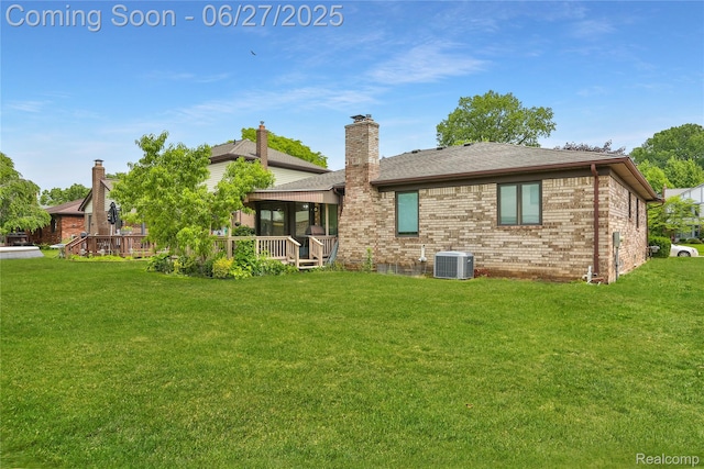 42471 Arcadia Dr, Sterling Heights, MI 48313 - rear view of house with a lawn, brick siding, a sunroom, and a shingled roof