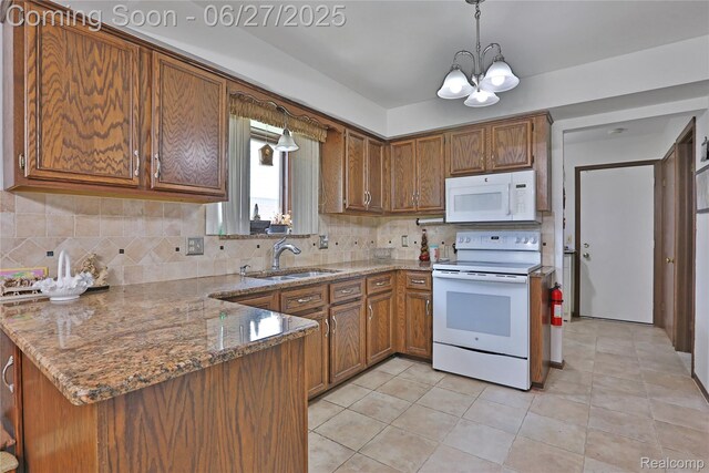 42471 Arcadia Dr, Sterling Heights, MI 48313 - kitchen featuring white appliances, brown cabinetry, a chandelier, a peninsula, and backsplash