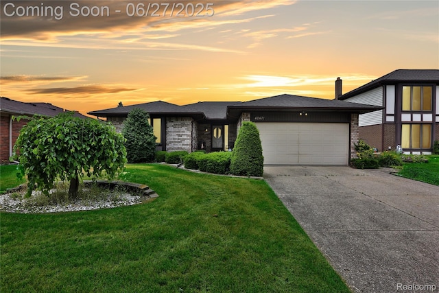 42471 Arcadia Dr, Sterling Heights, MI 48313 - view of front of home with a garage, a lawn, concrete driveway, and brick siding