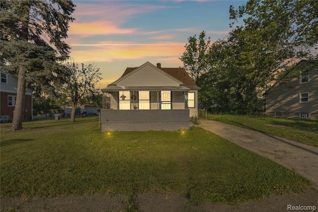 20258 Caldwell St, Detroit, MI 48234 - view of front facade featuring a lawn, a chimney, and covered porch