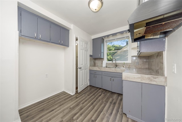 20258 Caldwell St, Detroit, MI 48234 - kitchen featuring gray cabinetry, dark wood-style flooring, light countertops, tasteful backsplash, and range hood