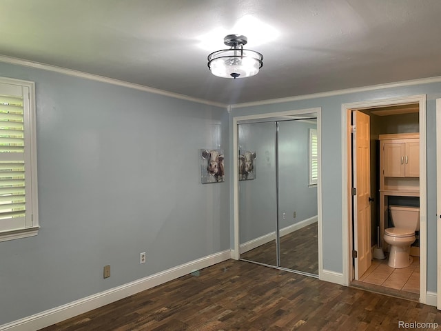 21150 E Chigwidden St, Northville, MI 48167 - unfurnished bedroom with dark wood-style flooring, crown molding, a closet, and connected bathroom