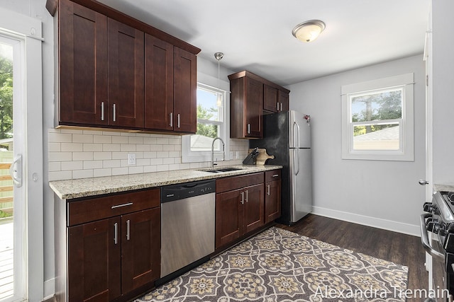 1602 4th St NW, Grand Rapids, MI 49504 - kitchen featuring appliances with stainless steel finishes, dark wood-style floors, decorative backsplash, and light stone countertops