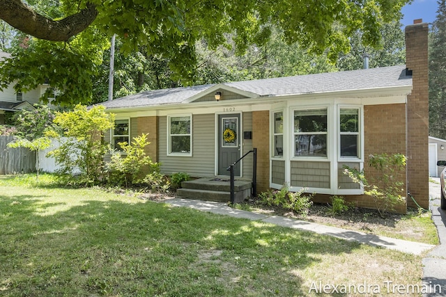 1602 4th St NW, Grand Rapids, MI 49504 - view of front of property with a front yard, a chimney, roof with shingles, and brick siding