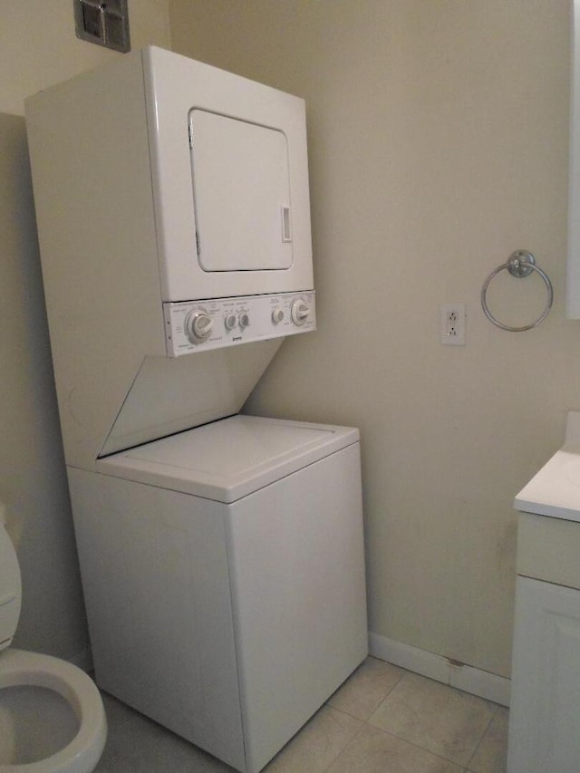 31831 Grand River Ave Unit 96, Farmington, MI 48336 - laundry room featuring stacked washer and clothes dryer and light tile patterned floors