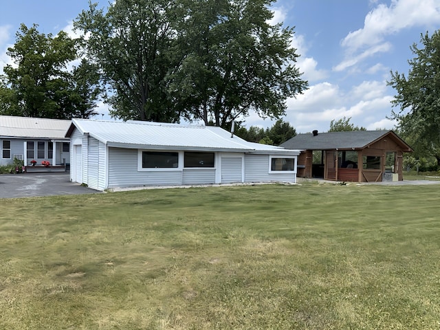 801 S 1st St, Buckley, MI 49620 - ranch-style house featuring a front yard, a metal roof, and a garage