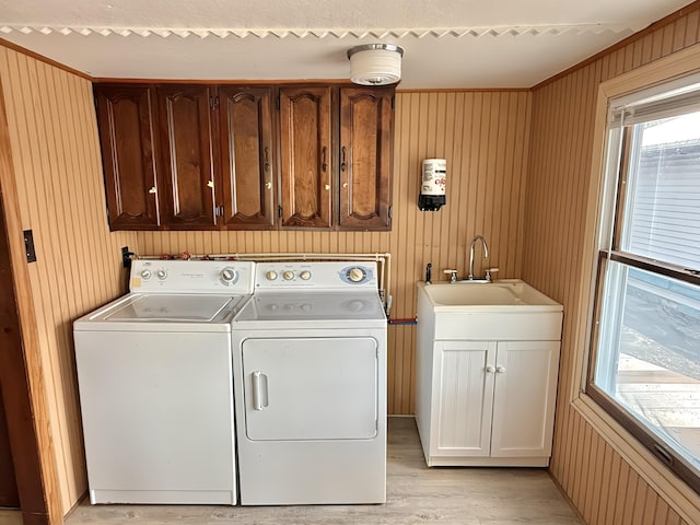 801 S 1st St, Buckley, MI 49620 - laundry room featuring separate washer and dryer, healthy amount of natural light, light wood finished floors, cabinet space, and wood walls