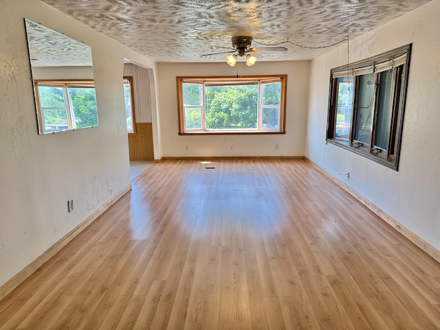 801 S 1st St, Buckley, MI 49620 - unfurnished dining area featuring ceiling fan, light wood finished floors, and a textured wall