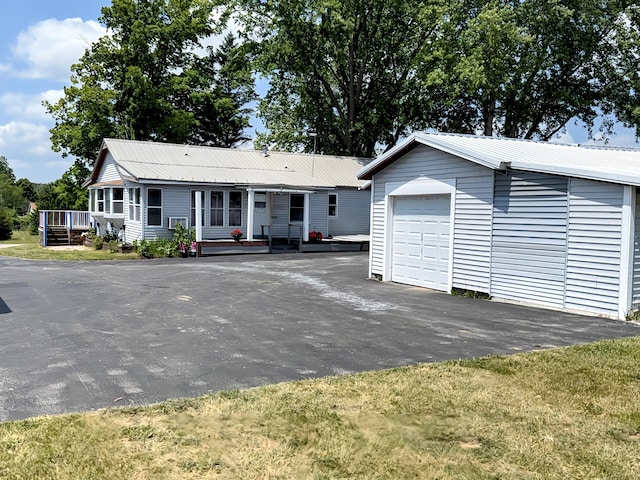801 S 1st St, Buckley, MI 49620 - ranch-style house with an outdoor structure, a metal roof, a wooden deck, and driveway