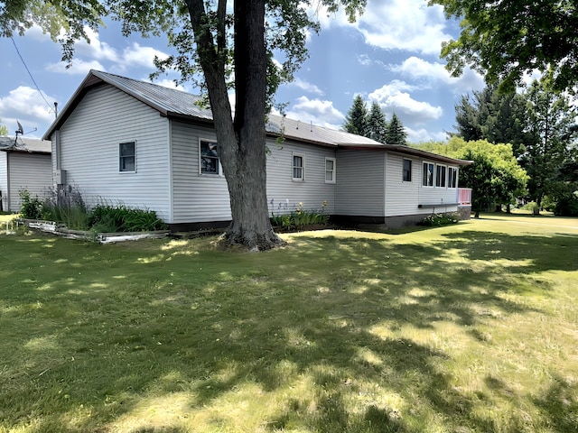801 S 1st St, Buckley, MI 49620 - view of property exterior featuring a yard and a metal roof