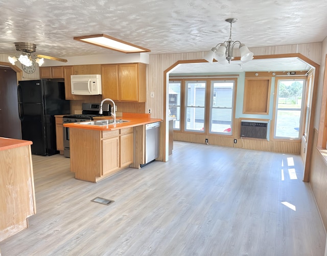 801 S 1st St, Buckley, MI 49620 - kitchen with appliances with stainless steel finishes, a peninsula, a chandelier, ceiling fan, and light wood finished floors