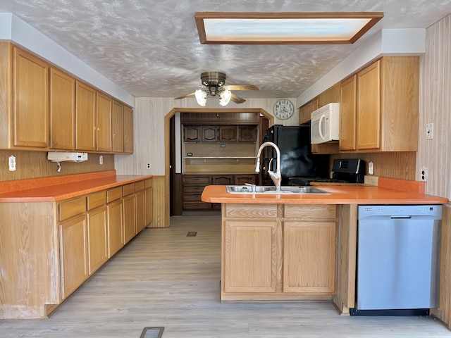 801 S 1st St, Buckley, MI 49620 - kitchen with dishwashing machine, white microwave, range, a peninsula, and a ceiling fan