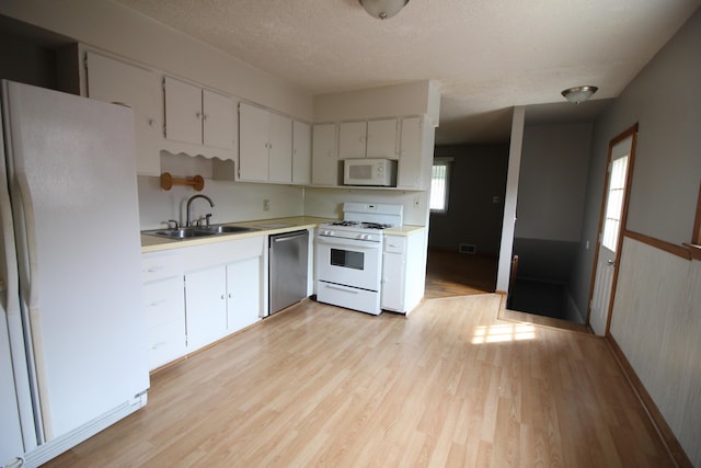 25652 Chernick St, Taylor, MI 48180 - kitchen featuring white appliances, light wood-style flooring, light countertops, a textured ceiling, and white cabinetry
