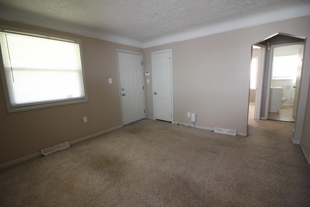 24352 Powers Ave, Dearborn Heights, MI 48125 - empty room with a textured ceiling, carpet flooring, and arched walkways