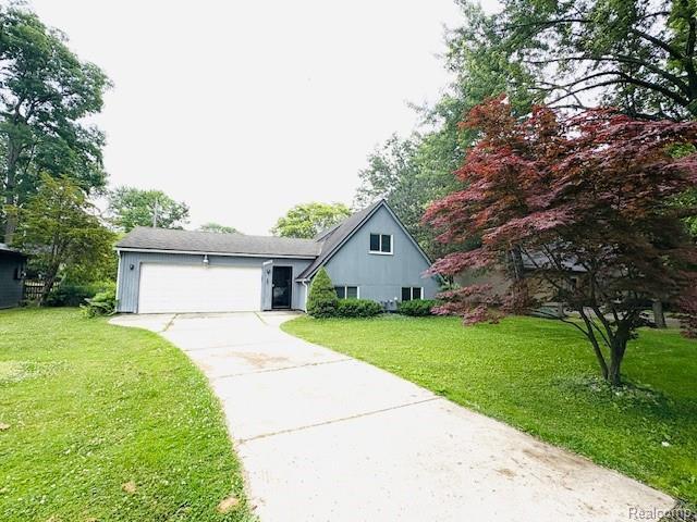 11638 Alois St, Livonia, MI 48150 - view of front of property featuring driveway, a garage, and a front lawn